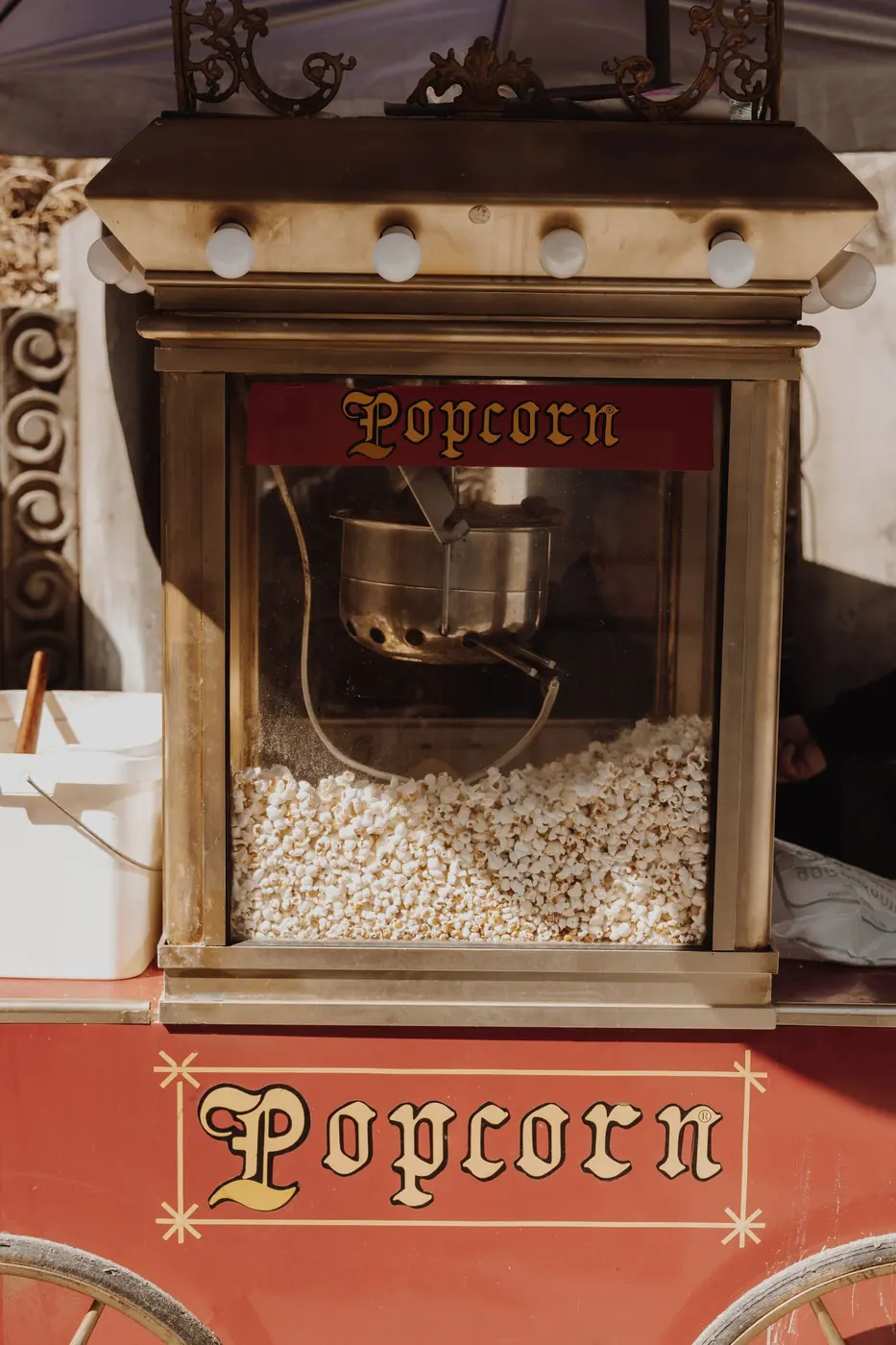A popcorn machine at a concession counter, with no people in the frame